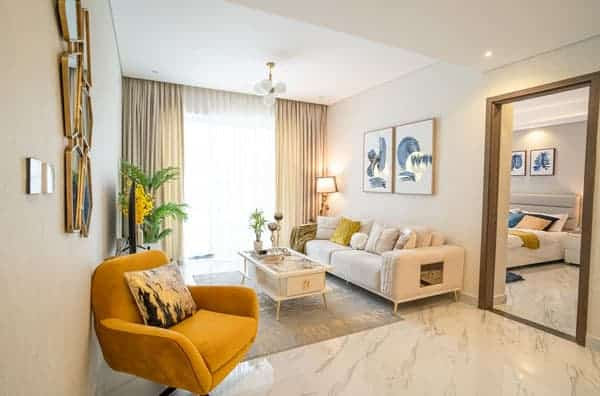 סלון מודרני ב-Gardenia Livings עם רצפת שיש, כורסה צהובה, ספה וכריות בצבע בז’, שולחן קפה, צמחי בית, תמונות על הקירות וחלונות גדולים עם וילונות שקופים. חדר השינה נראה מבעד לדלת הפתוחה. סלון מודרני ב-Gardenia Livings עם רצפת שיש, כורסה צהובה, ספה וכריות בצבע בז', שולחן קפה, צמחי בית, תמונות על הקירות וחלונות גדולים עם וילונות שקופים. חדר השינה נראה מבעד לדלת הפתוחה.