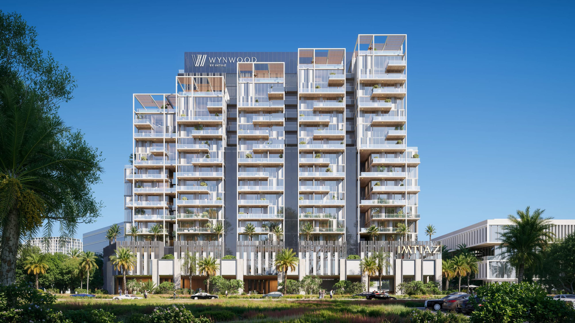 בניין דירות מודרני רב-קומתי עם מרפסות מזכוכית, עצי דקל וצמחייה מעוצבת בחזיתו, על רקע שמיים כחולים וצלולים. על שלטי הבניין כתוב “WYNWOOD” ו-“WYNAZ”. בניין דירות מודרני רב-קומתי עם מרפסות מזכוכית, עצי דקל וצמחייה מעוצבת בחזיתו, על רקע שמיים כחולים וצלולים. על שלטי הבניין כתוב "WYNWOOD" ו-"WYNAZ".