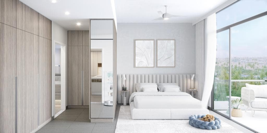 חדר שינה מואר ומודרני ב-Kensington Waters, הכולל מיטה גדולה, ארונות קיר מעץ בהיר, שתי יצירות אמנות ממוסגרות, חלונות מהרצפה עד התקרה וכלב קטן הישן על מיטה רכה. בחוץ נראית מרפסת עם פינת ישיבה. חדר שינה מואר ומודרני ב-Kensington Waters, הכולל מיטה גדולה, ארונות קיר מעץ בהיר, שתי יצירות אמנות ממוסגרות, חלונות מהרצפה עד התקרה וכלב קטן הישן על מיטה רכה. בחוץ נראית מרפסת עם פינת ישיבה.