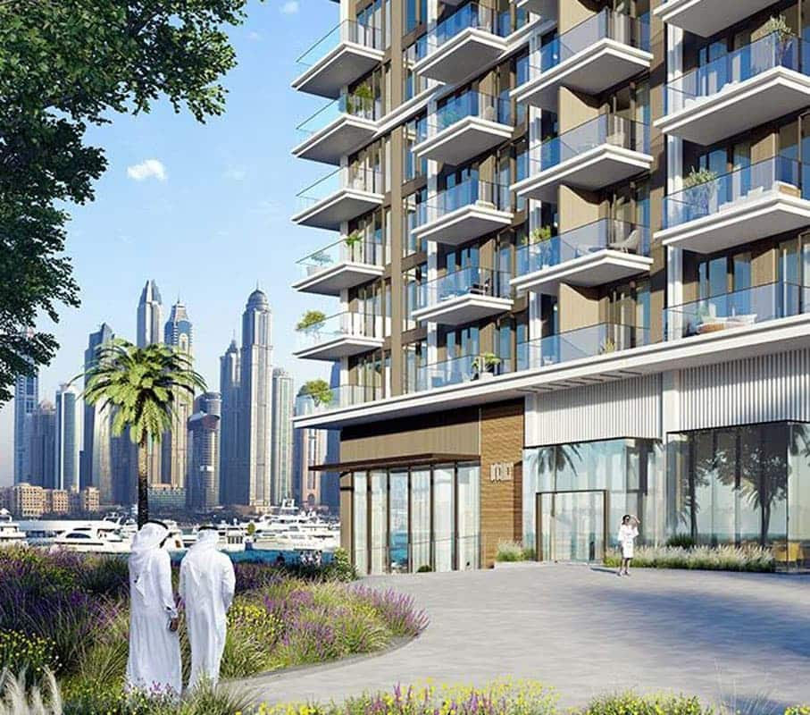 בניין דירות מודרני של חברת Emaar הממוקם על קו החוף, עם מרפסות רבות, גינון שופע, ואנשים לבושים בבגדים לבנים מסורתיים המטיילים במקום. ברקע, מעבר למים, נראים גורדי שחקים ועצי דקל. בניין דירות מודרני של חברת Emaar הממוקם על קו החוף, עם מרפסות רבות, גינון שופע, ואנשים לבושים בבגדים לבנים מסורתיים המטיילים במקום. ברקע, מעבר למים, נראים גורדי שחקים ועצי דקל.