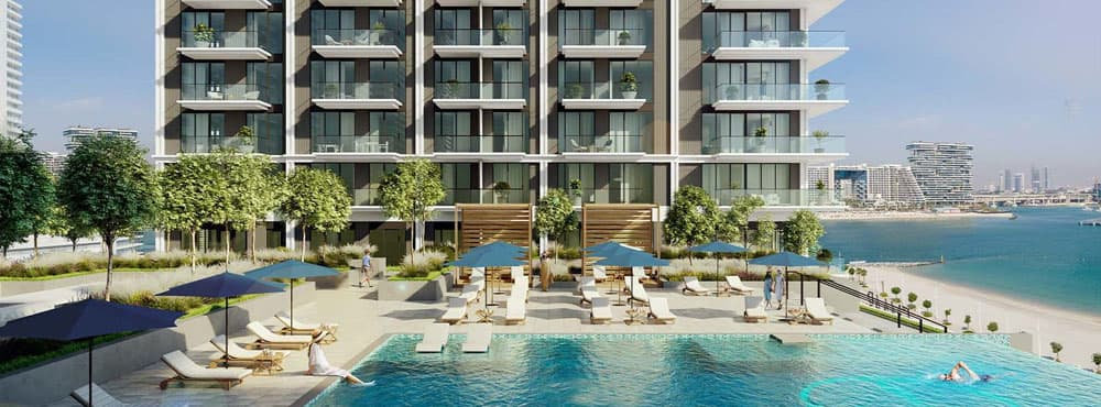 בניין דירות מודרני של חברת Emaar הממוקם על קו החוף, עם מרפסות המשקיפות על בריכת שחייה גדולה. סביבו פזורים מיטות שיזוף ושמשיות כחולות, וברקע נפרש נוף מרהיב של האוקיינוס ושל גורדי השחקים בעיר. בניין דירות מודרני של חברת Emaar הממוקם על קו החוף, עם מרפסות המשקיפות על בריכת שחייה גדולה. סביבו פזורים מיטות שיזוף ושמשיות כחולות, וברקע נפרש נוף מרהיב של האוקיינוס ושל גורדי השחקים בעיר.