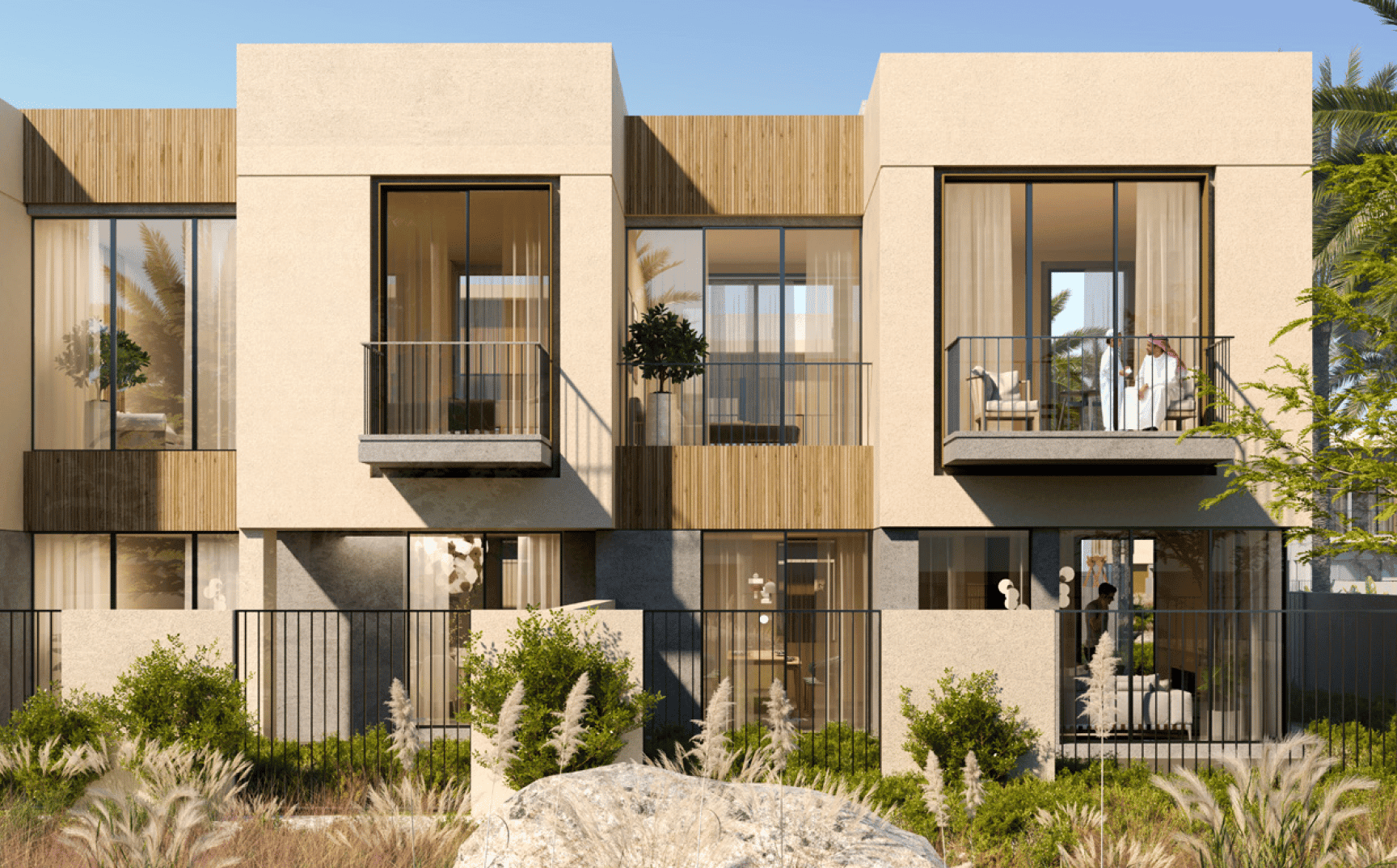בית מודרני בן שתי קומות עם חלונות זכוכית גדולים ומרפסות, קירות בצבע בז’, אלמנטים מעץ וגינה קטנה בחזית, כפי שנראה ביום שטוף שמש. מבעד לחלונות נראים שני אנשים בתוך הבית. בית מודרני בן שתי קומות עם חלונות זכוכית גדולים ומרפסות, קירות בצבע בז', אלמנטים מעץ וגינה קטנה בחזית, כפי שנראה ביום שטוף שמש. מבעד לחלונות נראים שני אנשים בתוך הבית.