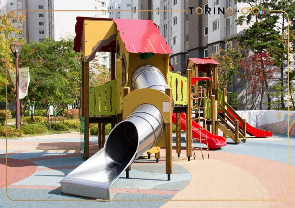 בפרויקט “טורינו” של ORO24 ניצב מגרש משחקים צבעוני הכולל מגלשות, מתקני טיפוס ומגלשת מנהרה מתכתית גדולה, המונחים על משטח רך ומעוטר בדוגמאות. בנייני דירות ועצים מקיפים את אזור המשחקים התוסס. בפרויקט "טורינו" של ORO24 ניצב מגרש משחקים צבעוני הכולל מגלשות, מתקני טיפוס ומגלשת מנהרה מתכתית גדולה, המונחים על משטח רך ומעוטר בדוגמאות. בנייני דירות ועצים מקיפים את אזור המשחקים התוסס.