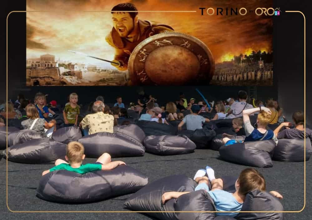 ילדים ומבוגרים נרגעים על פופים בחוץ, וצופים בסרט “גלדיאטור” על מסך ענק. האירוע, המתקיים תחת חסות “טורינו אורה” ומהווה חלק מ-ORO24, מאחד את הקהילה לערב קולנוע בלתי נשכח. ילדים ומבוגרים נרגעים על פופים בחוץ, וצופים בסרט "גלדיאטור" על מסך ענק. האירוע, המתקיים תחת חסות "טורינו אורה" ומהווה חלק מ-ORO24, מאחד את הקהילה לערב קולנוע בלתי נשכח.